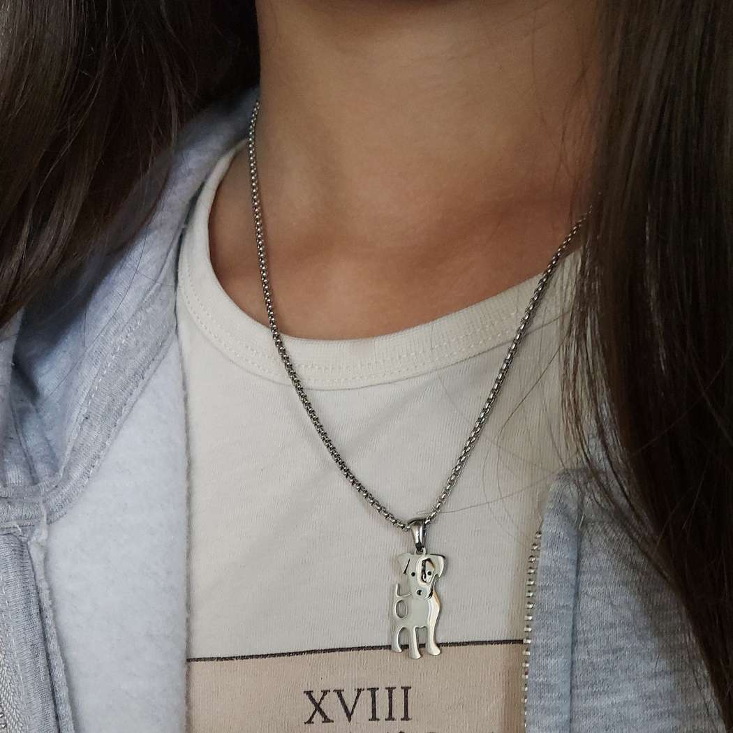Collar para mujer o niña con forma de perro ratonero sobre camiseta beige encuello de modelo. TOUS