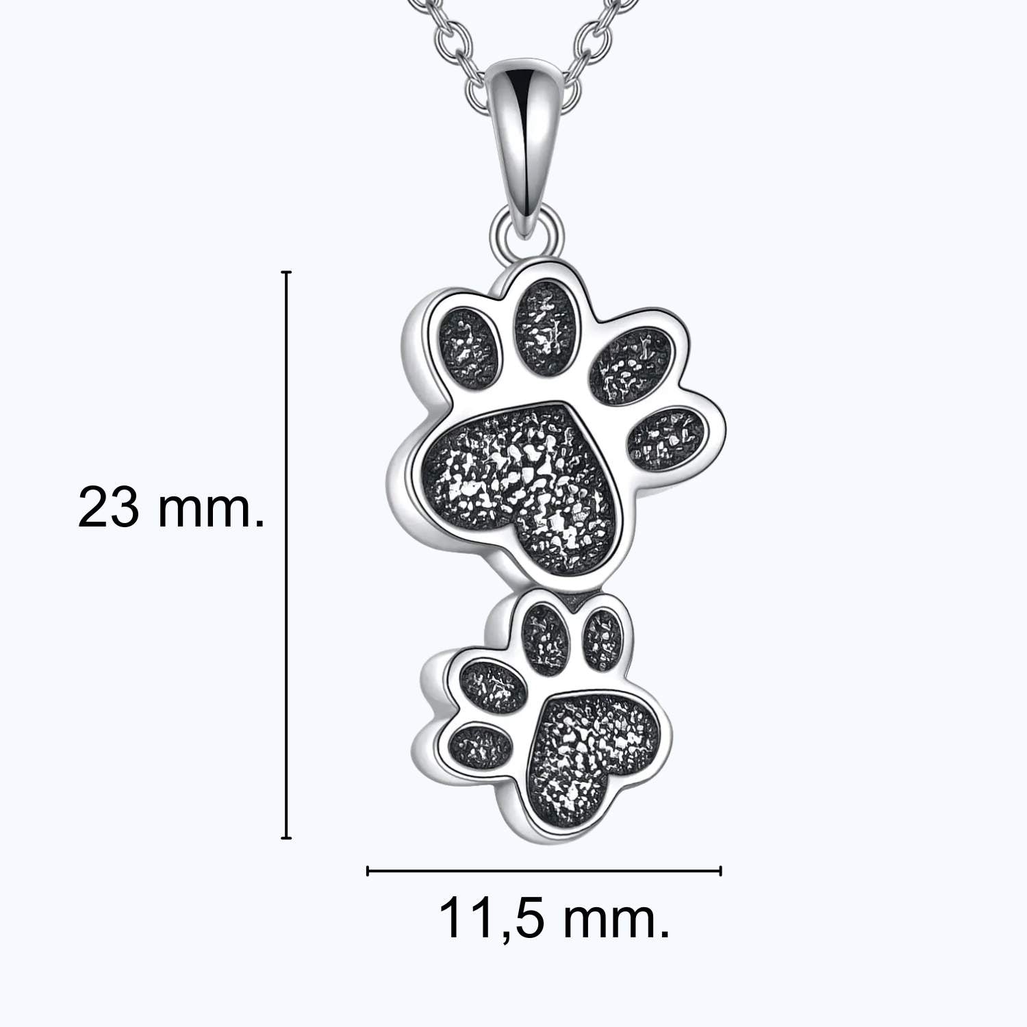 Infografía con las medidas del colgante para cenizas con 2 huellas de TOUS: 23 mm. de alto por 11,5 de ancho