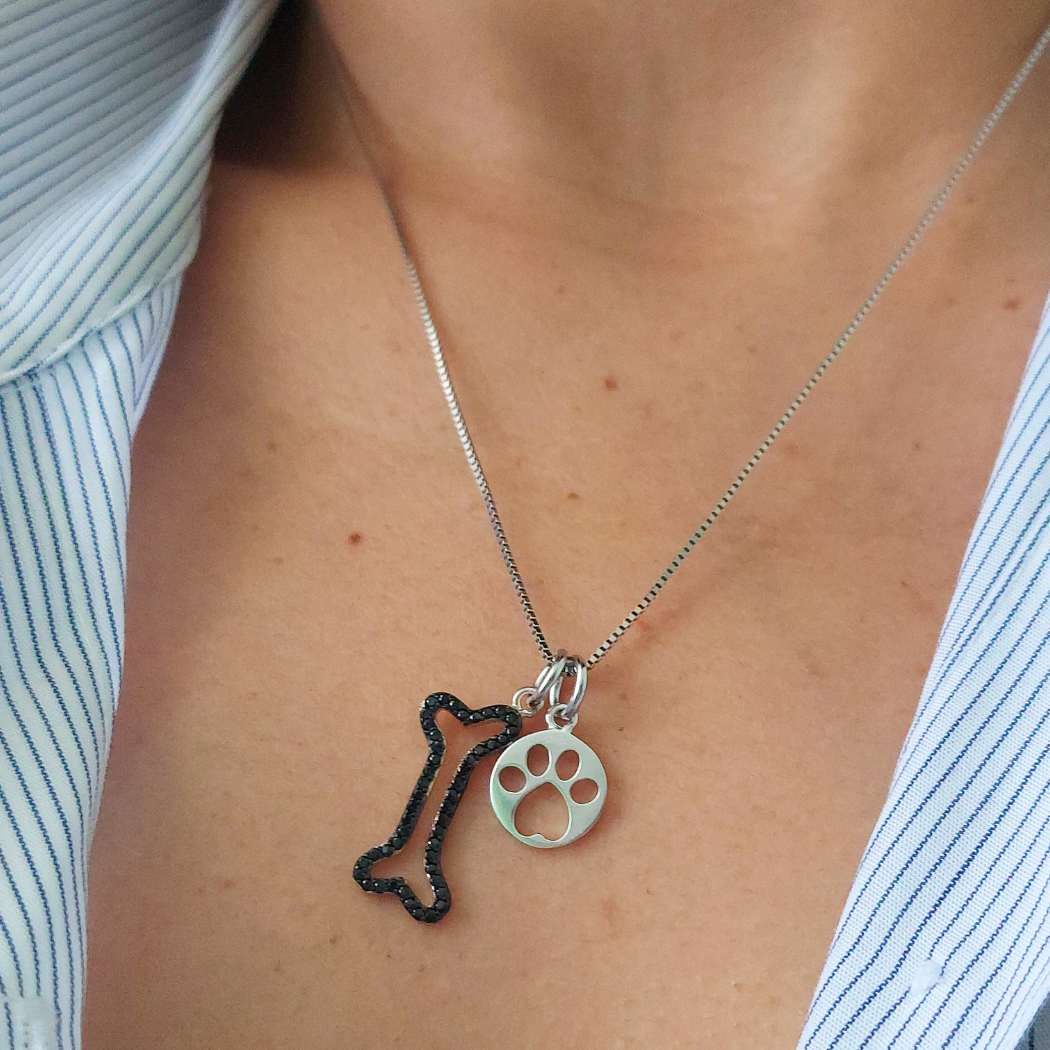 Collar con colgante de huesito negro y huella de perro en plata de ley, en cuello de mujer. PANDORA