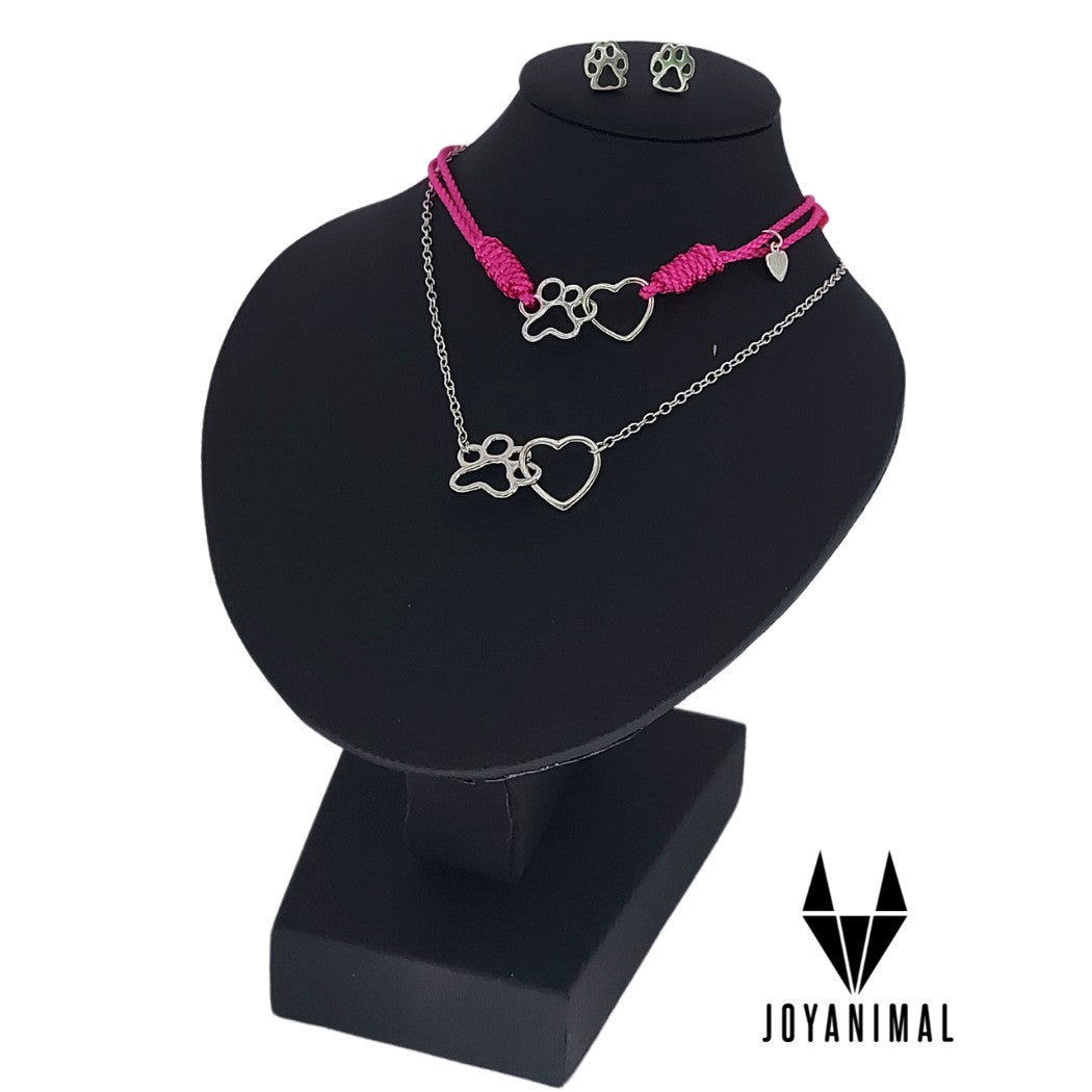 Pendientes y collar de plata con patitas de perros o gatos y corazones con pulsera de hilo rosa a juego, expuesta en el corte ingles en busto negro.