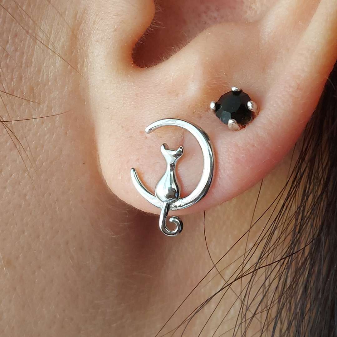 Pendiente de plata en oreja de modelo junto a otro pendiente adicional de Pandora