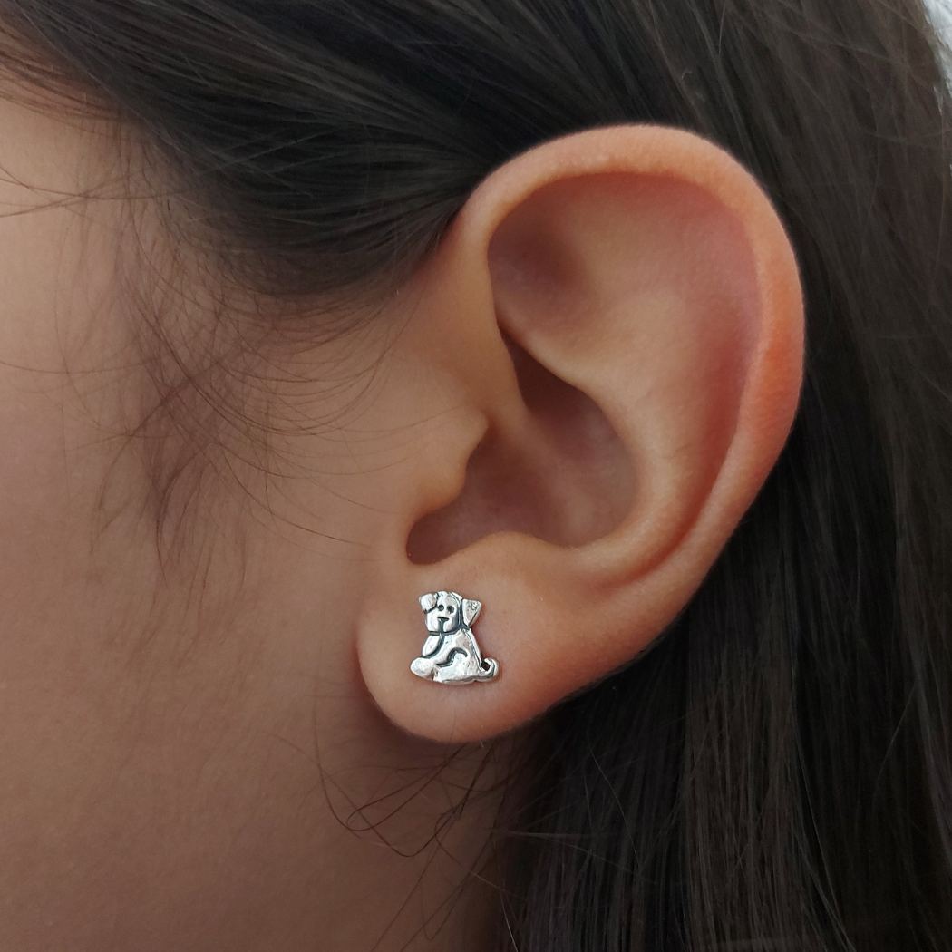 Pendientes de plata con forma de perrito, en oreja de chica adolescente. PANDORA