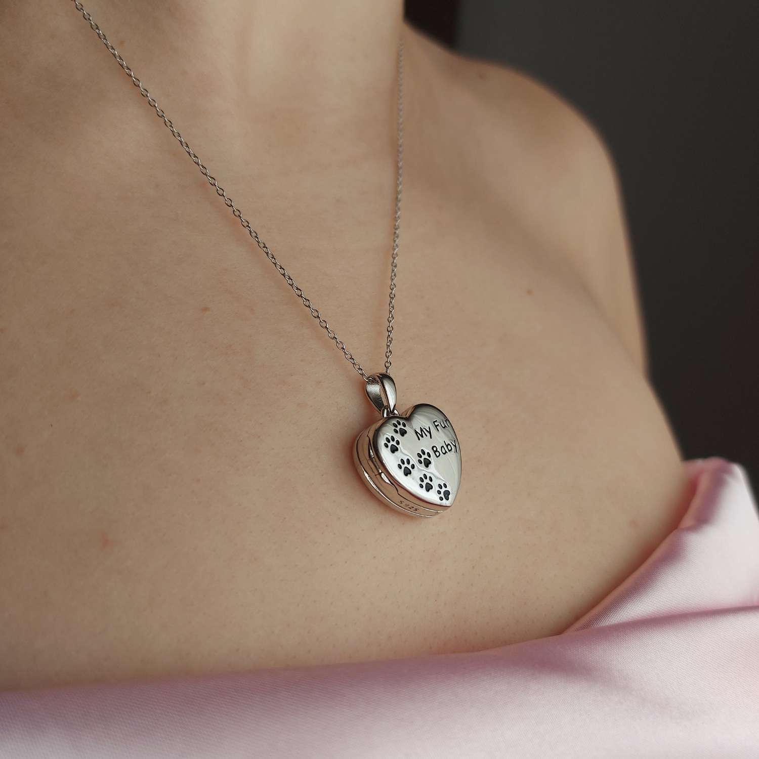 Medallon de plata con forma de corazón con huellas negras grabadas para guardar fotos de el corte inglés