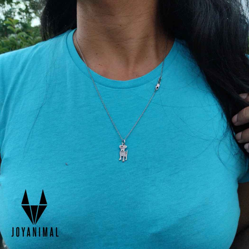 Collar para mujer o niña con forma de perrito ratonero sobre camiseta azul en cuello de modelo.