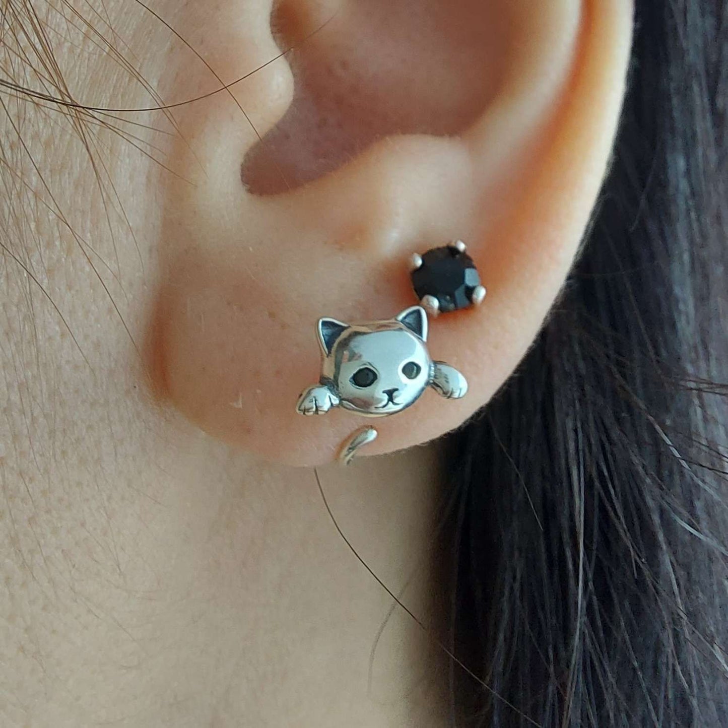 Pendiente con gato escapando de la oreja de una modelo junto con pendiente de PANDORA