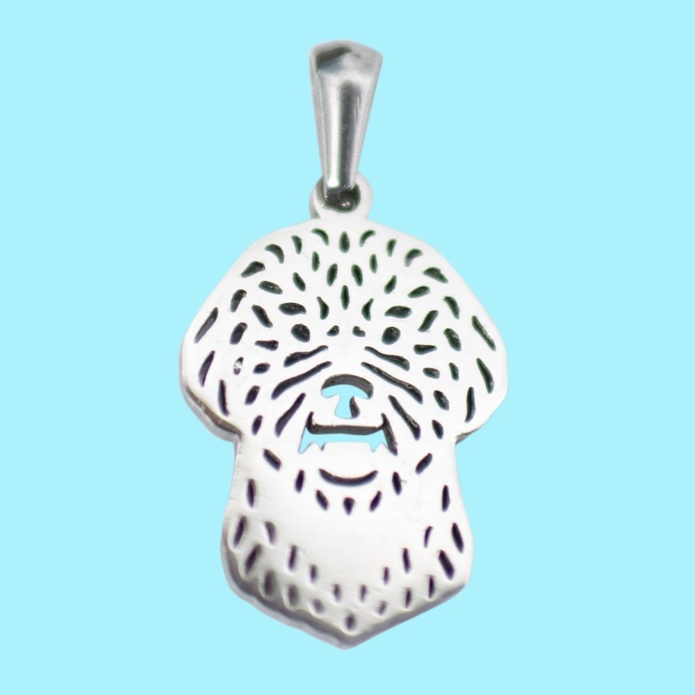 Colgante de perrito caniche toy en relieve, color plata sobre fondo vende de el corte inglés.