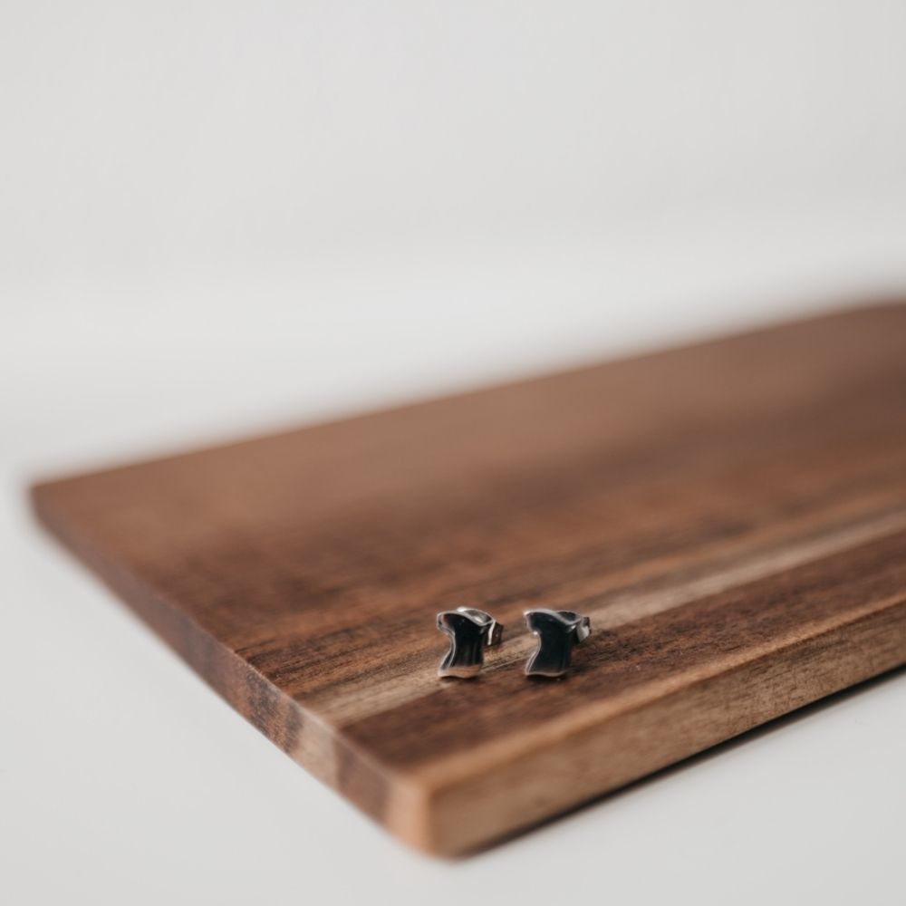 Pendientes pequeños especiales para niña con forma de perrito Bull terrier, sobre una tabla de madera del corte inglés