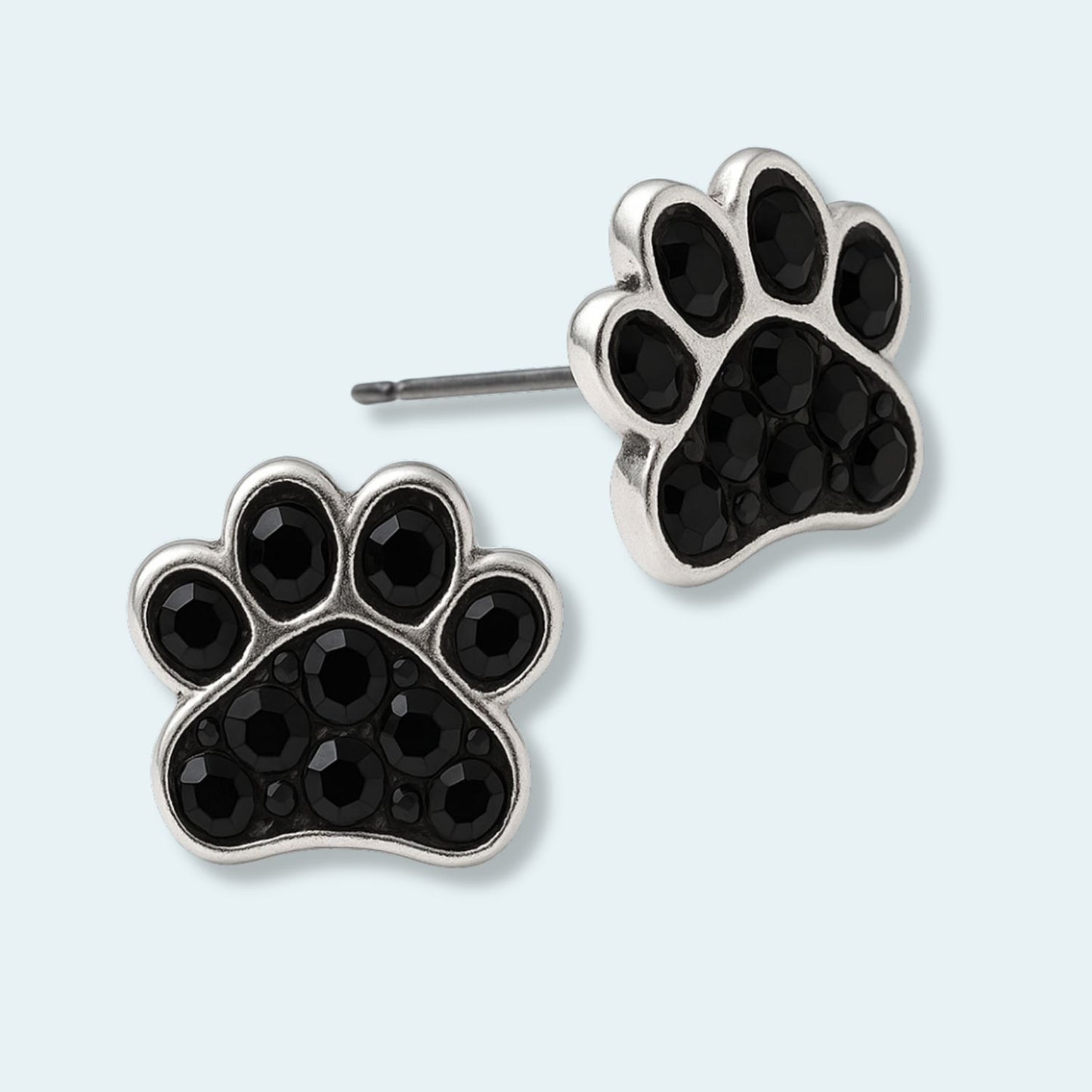 Pendientes huella plata y zirconia negra sobre fondo turquesa, TOUS.