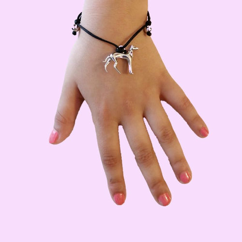 Pulsera hilo negro ajustable sobre mano de niña, destaca la silueta de un galgo plata PANDORA