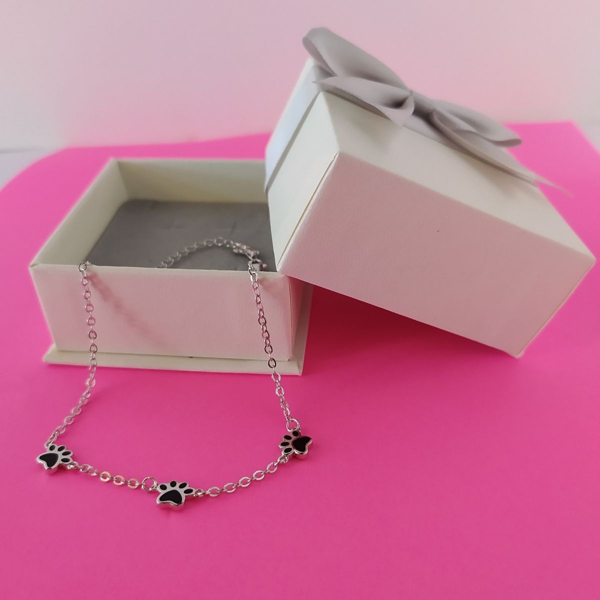 Pulsera con huellitas negras de gatos o perros en una cajita de regalo de el corte inglés