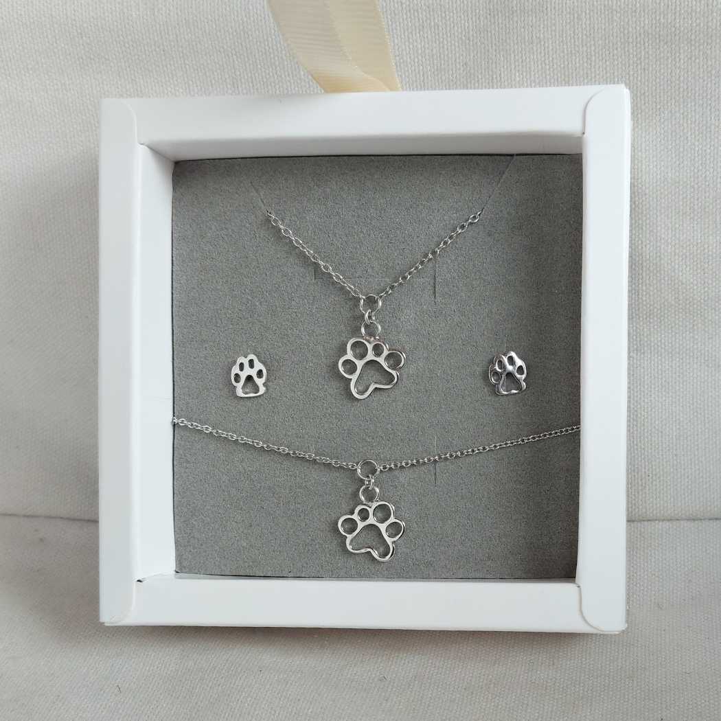 Conjunto de joyas de plata formado por collar, pulsera y pendientes con la silueta de un perro o gato en plata de ley, presentados en una caja blanca del corte inglés