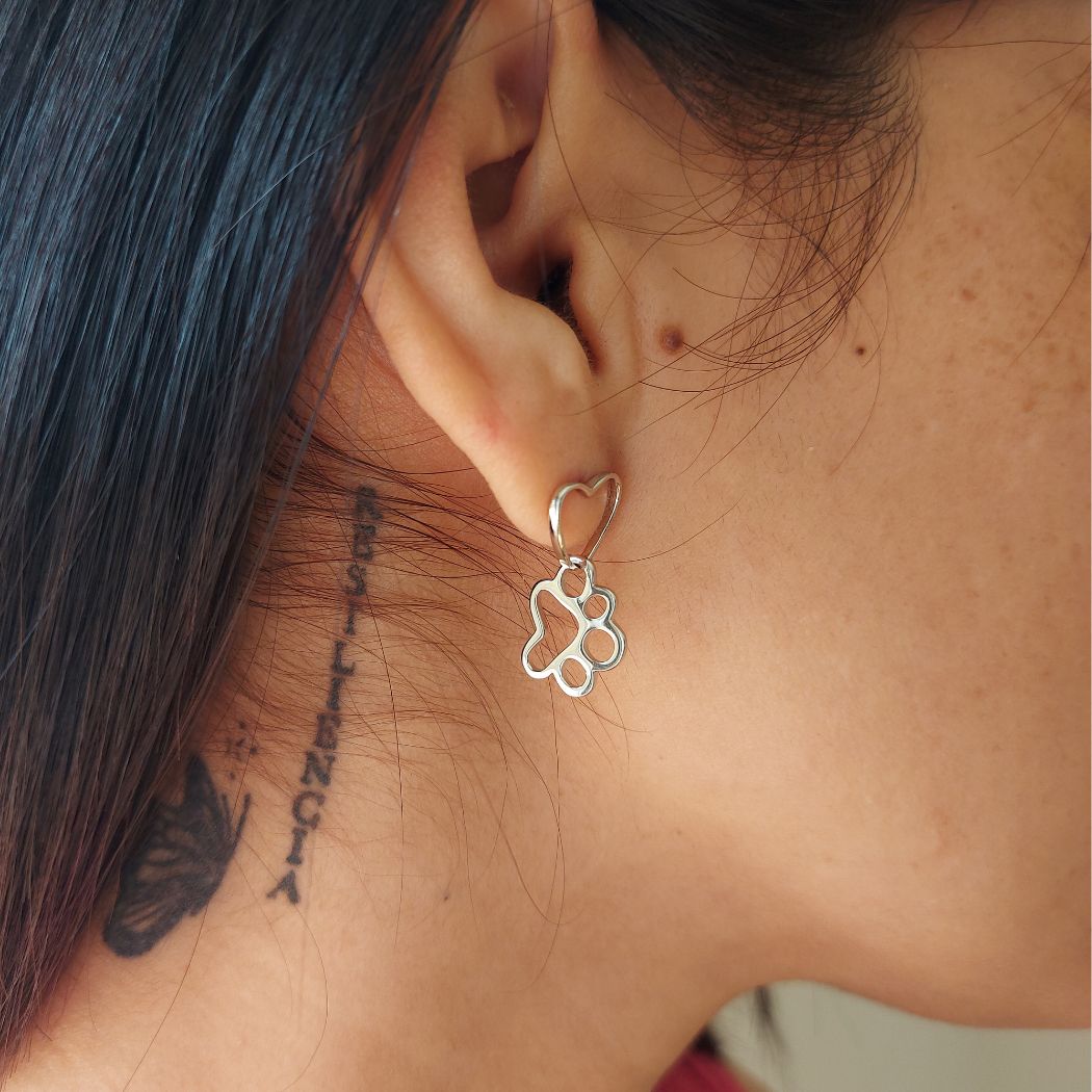 Pendiente de plata con huella de perro colgante de pandora con corazon en oreja de modelo mujer