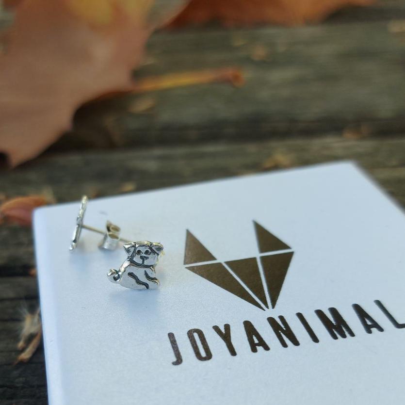 Pendientes de plata con forma de perrito, encima de una caja de regalo de JOYANIMAL