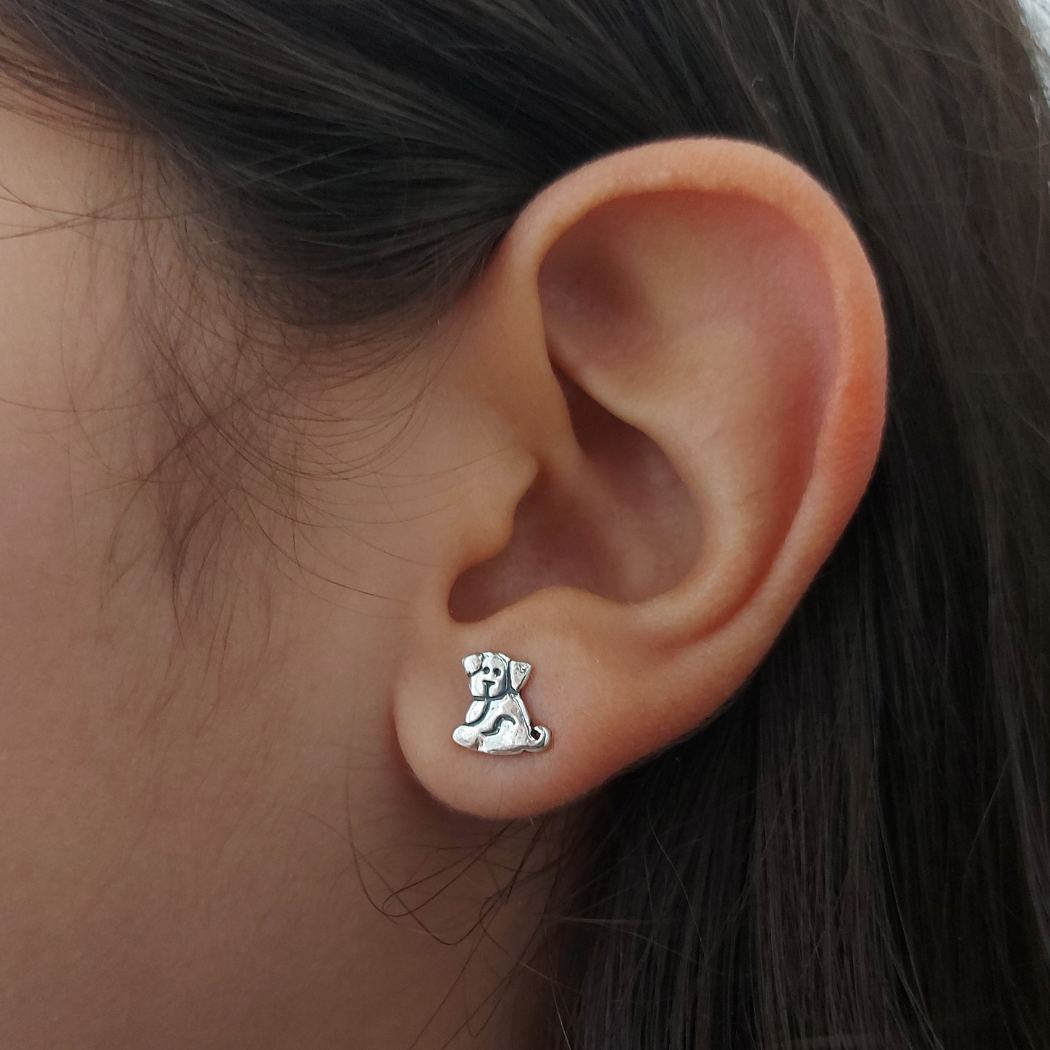 Pendientes de plata con forma de perro, en oreja de chica adolescente. PANDORA