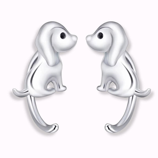 Pendientes de plata con forma de perritos con la cola larga, sobre fondo blanco de el corte inglés
