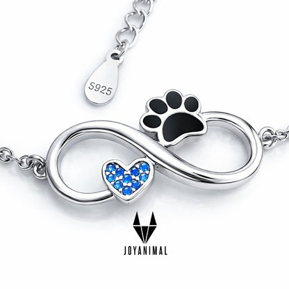 Pulsera con símbolo del infinito con un corazón y una pata de peludo, junto al mini colgante de plata S925, la pulsera simboliza el amor infinito a nuestros perros o gatos, sobre fondo azul  de PANDORA