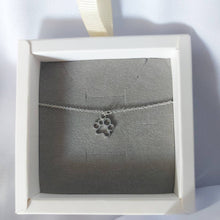 Cadena fina de plata con colgante de huella de mascota en su cajita para regalo de El corte ingles.