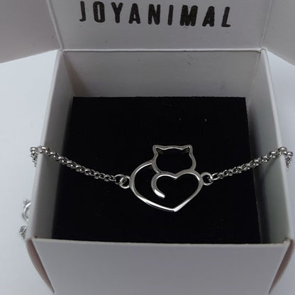 Pulsera de plata con forma de corazón y gato sobre caja de regalo del corte inglés