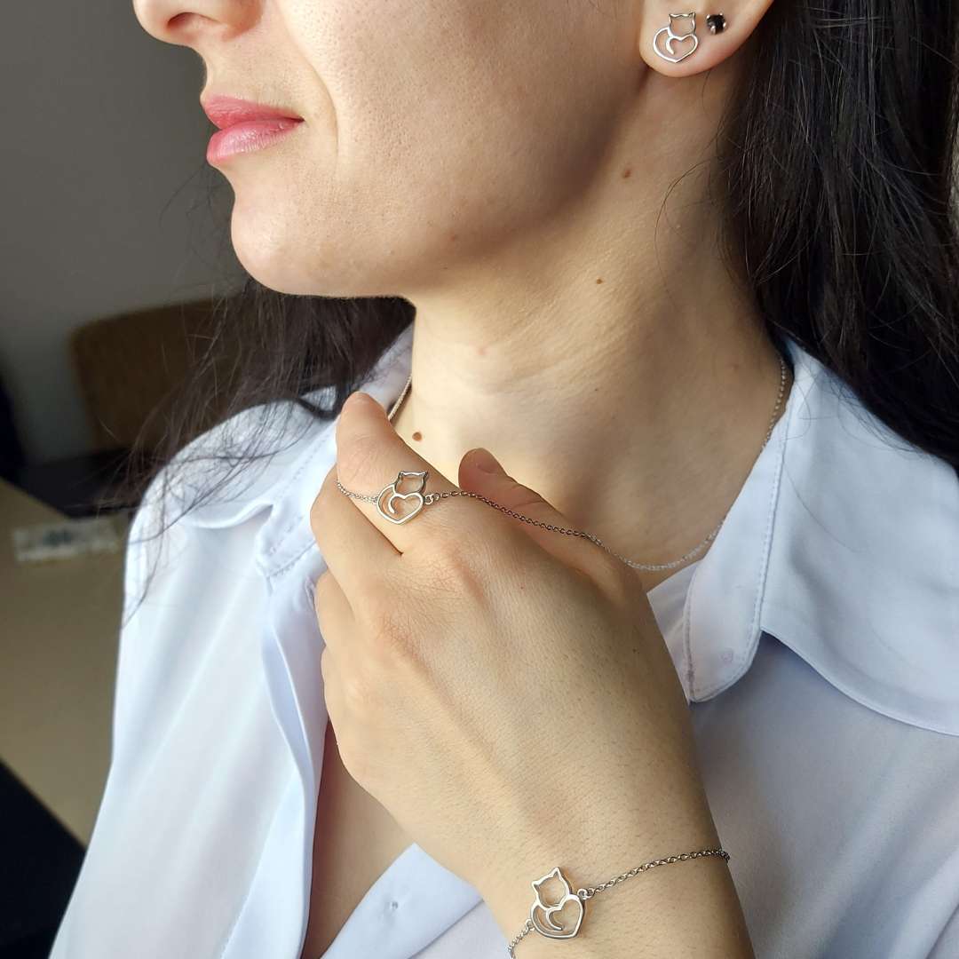 Modelo mujer mostrando pulsera, collar y pendientes de plata con gatos y corazones de pandora