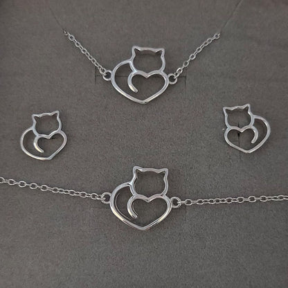 Collar, pulsera y pendientes de plata con forma de gatitos y corazones sobre fondo gris del corte inglés