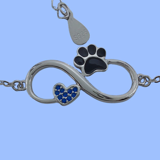 Pulsera con símbolo del infinito con un corazón y una huella de peludo, junto al mini colgante de plata S925, la pulsera simboliza el amor infinito a nuestros perros o gatos, sobre fondo azul  de pandora