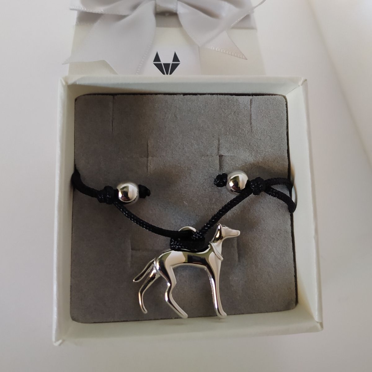 Pulsera para niñas de Galgo dentro de una cajita de regalo con lazo del corte inglés.