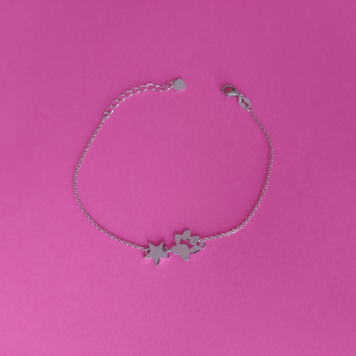 Pulsera con huella de mascota con estrella de plata, sobre fondo rosa