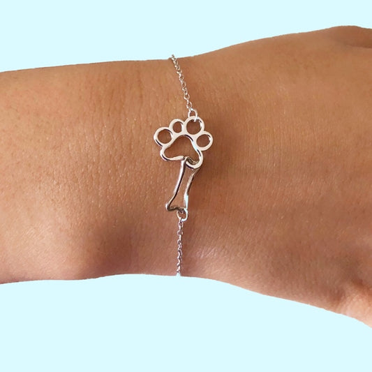 pulsera de plata con huella de perro y hueso de pandora. Vestido en muñeca de mujer